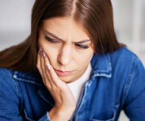 Female holding her mouth in pain