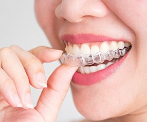 Nose-to-chin closeup of woman putting Invisalign over upper arch