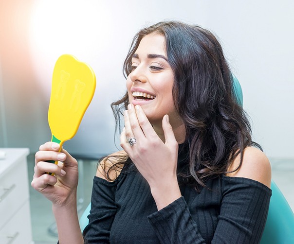 Woman in dentist’s chair looking in mirror