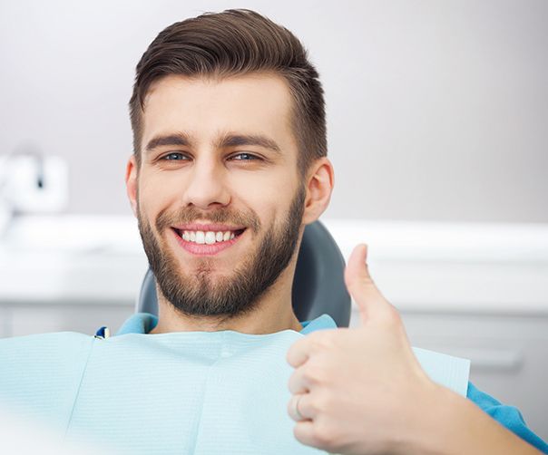 Man holding thumb up at dental appointment