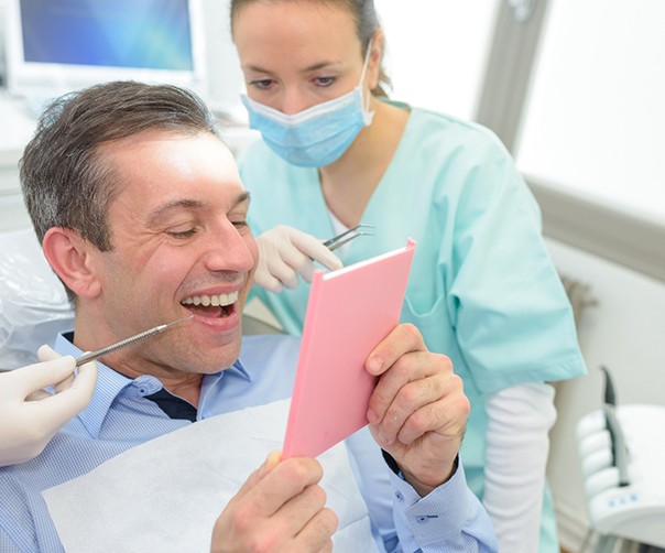 Patient looking in mirror at dental crown