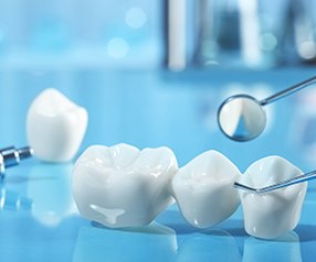 The parts of a dental implant and bridge on a light blue background