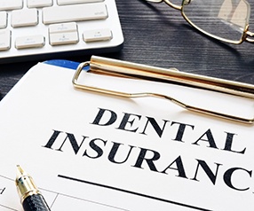 A dental insurance form and a pen on a desk