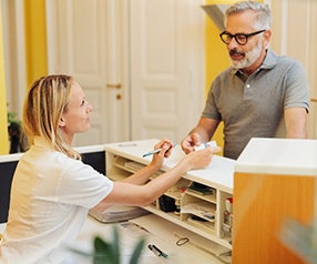 An older man paying the cost of dentures