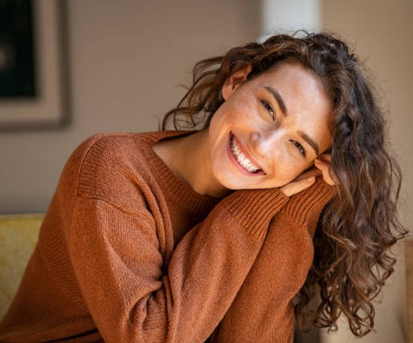 Smiling woman resting her head on her hands