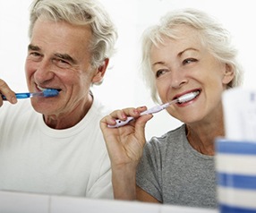 couple with dental implants in Tyler brushing their teeth together