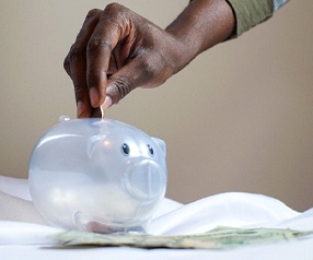 Hand putting coin in piggy bank