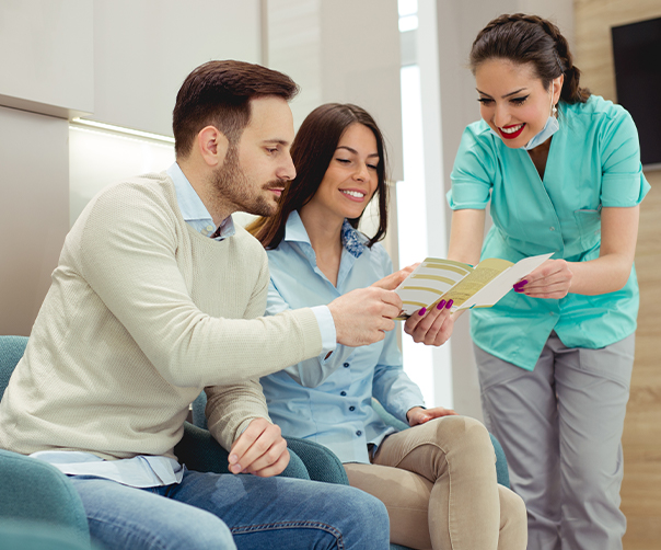 Dental team member showing patients dental insurance forms