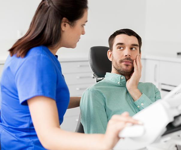 Man in need of root canal therapy holding cheek