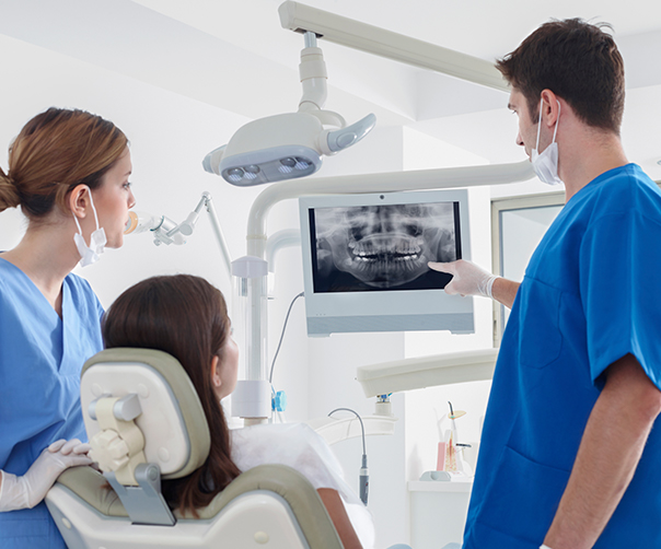 Dentist and patient looking at digital x-rays