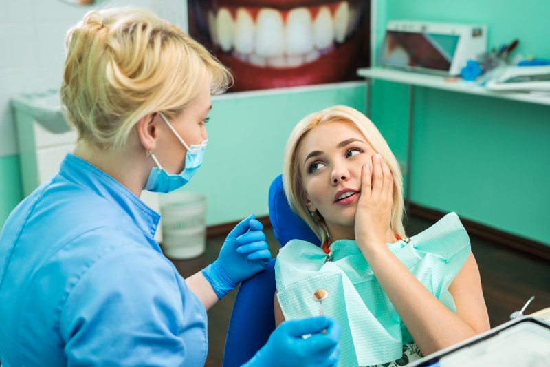 Woman with toothache with dental hygienist
