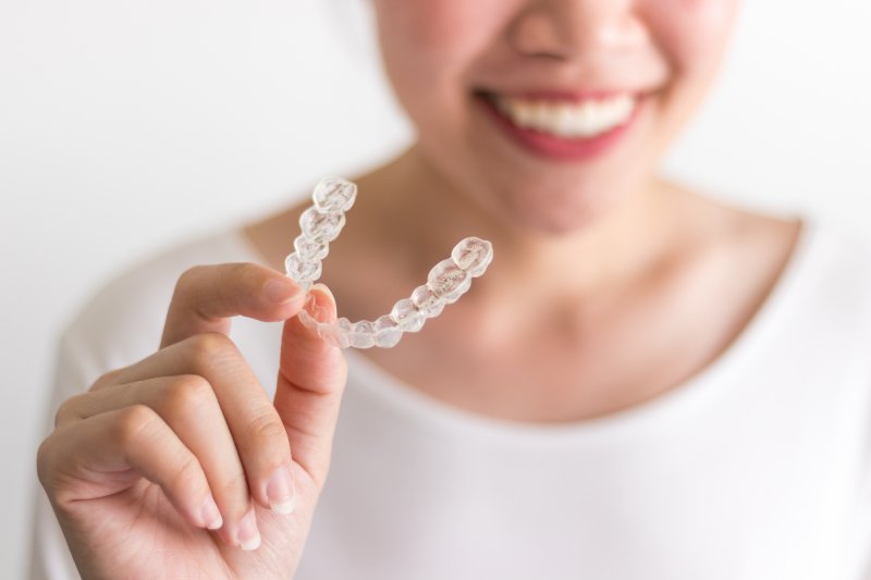 a closeup of a patient holding Invisalign