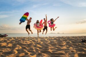 People jumping mid-air on beach.